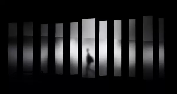 zum Dossier (Schatten hinter Spiegel als Symbolbild für Einsamkeit. Foto: Photo by David Werbrouck on Unsplash.com)